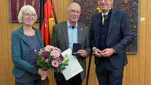 Bürgermeister Armin Pollehn (rechts) und Birgit Meinig überreichen die Bürgermedaille an Matthias Schorr.