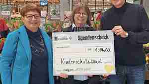 Marktleiterin Astrid Kroß (Mitte) überreicht den symbolischen Scheck an Bärbel Börges und Bastian Hellberg vom Kinderschutzbund.