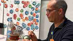 Der Schriftsteller Ingo Siegner bemalt Weihnachtsbaumkugeln.