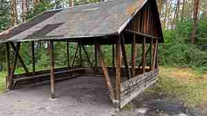 Die Grillhütte ist massiv beschädigt. Daneben finden sich Reste eines offenen Lagerfeuers.