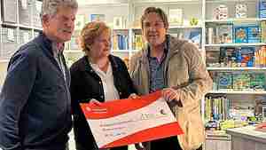 Kabarettist Matthias Brodowy (von rechts) und Buchhändlerin Gaby Frey übergeben den symbolischen Scheck an Bastian Hellberg vom Kinderschutzbund.